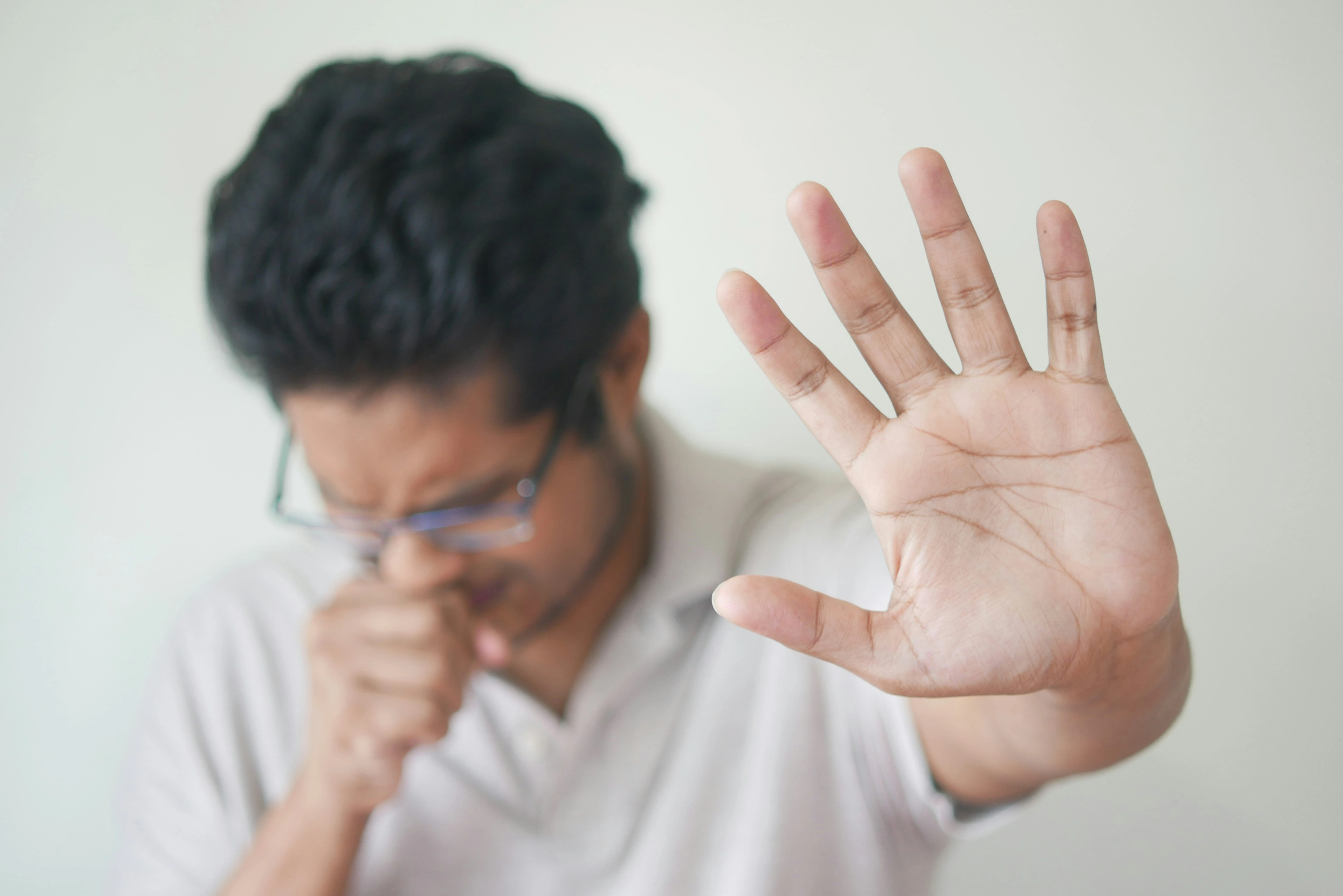 photo of a person having an acid reflux flare up and holding up their hand