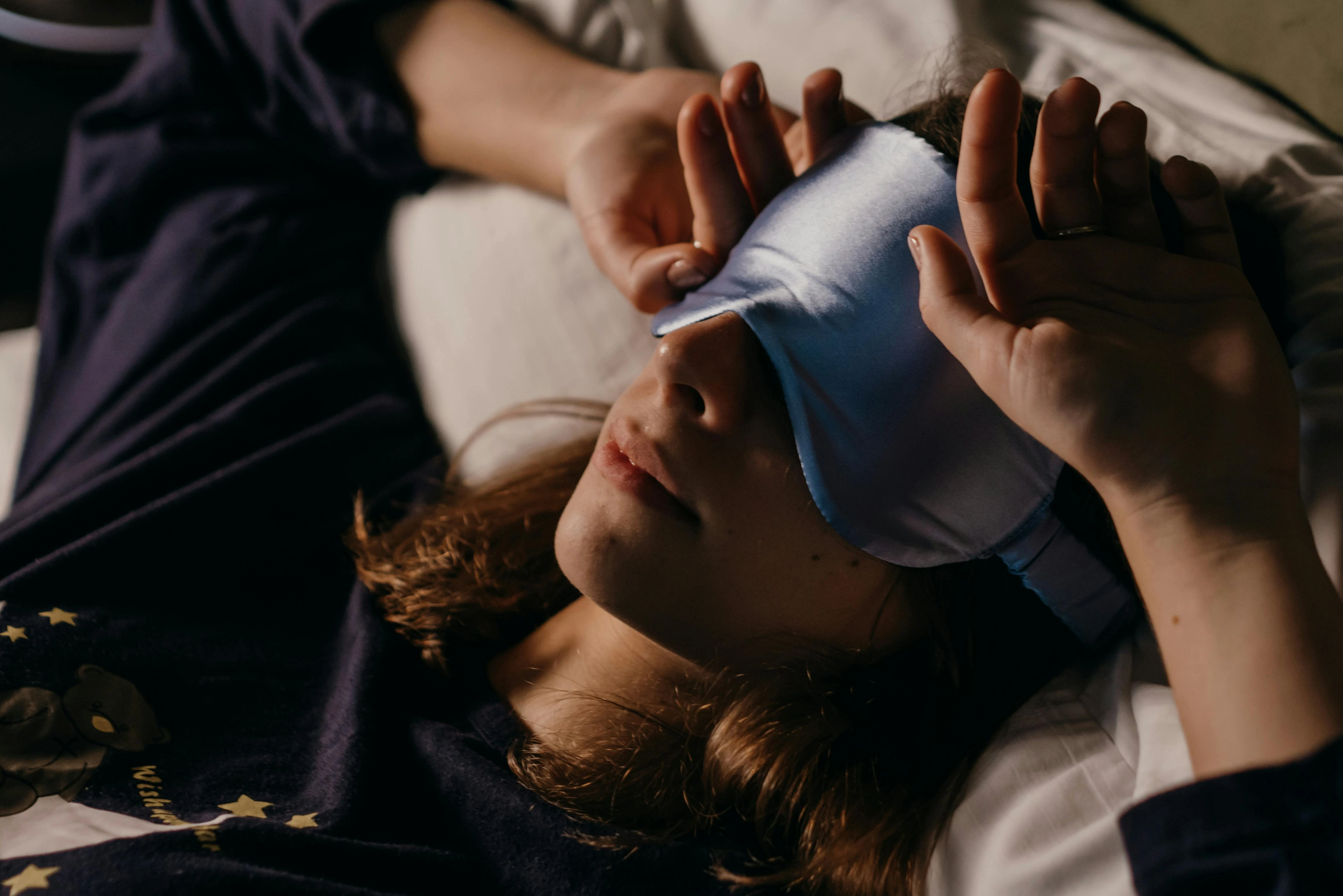 person wearing a sleep mask to cure sleep inertia