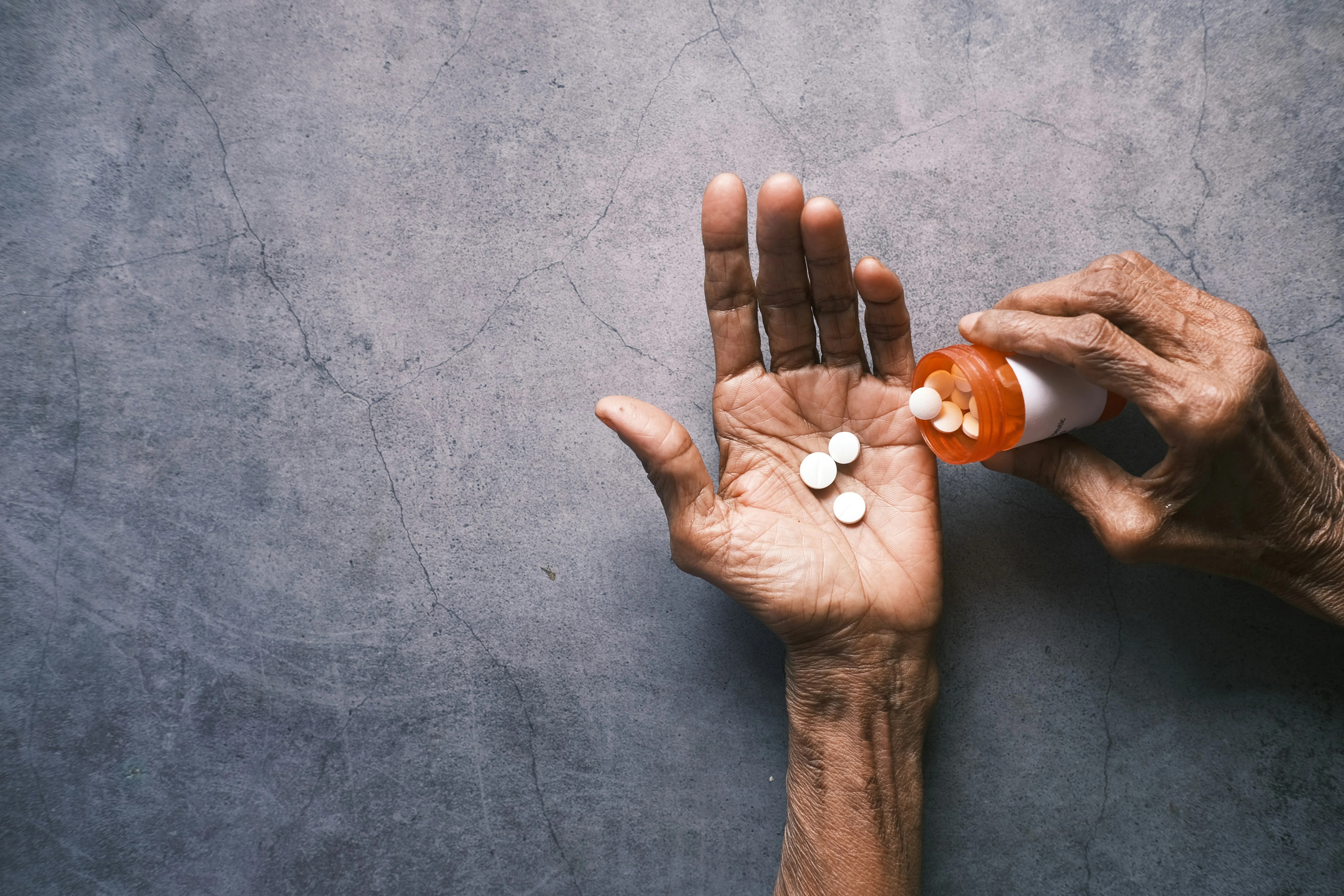 photo of a person putting pills into their open hand