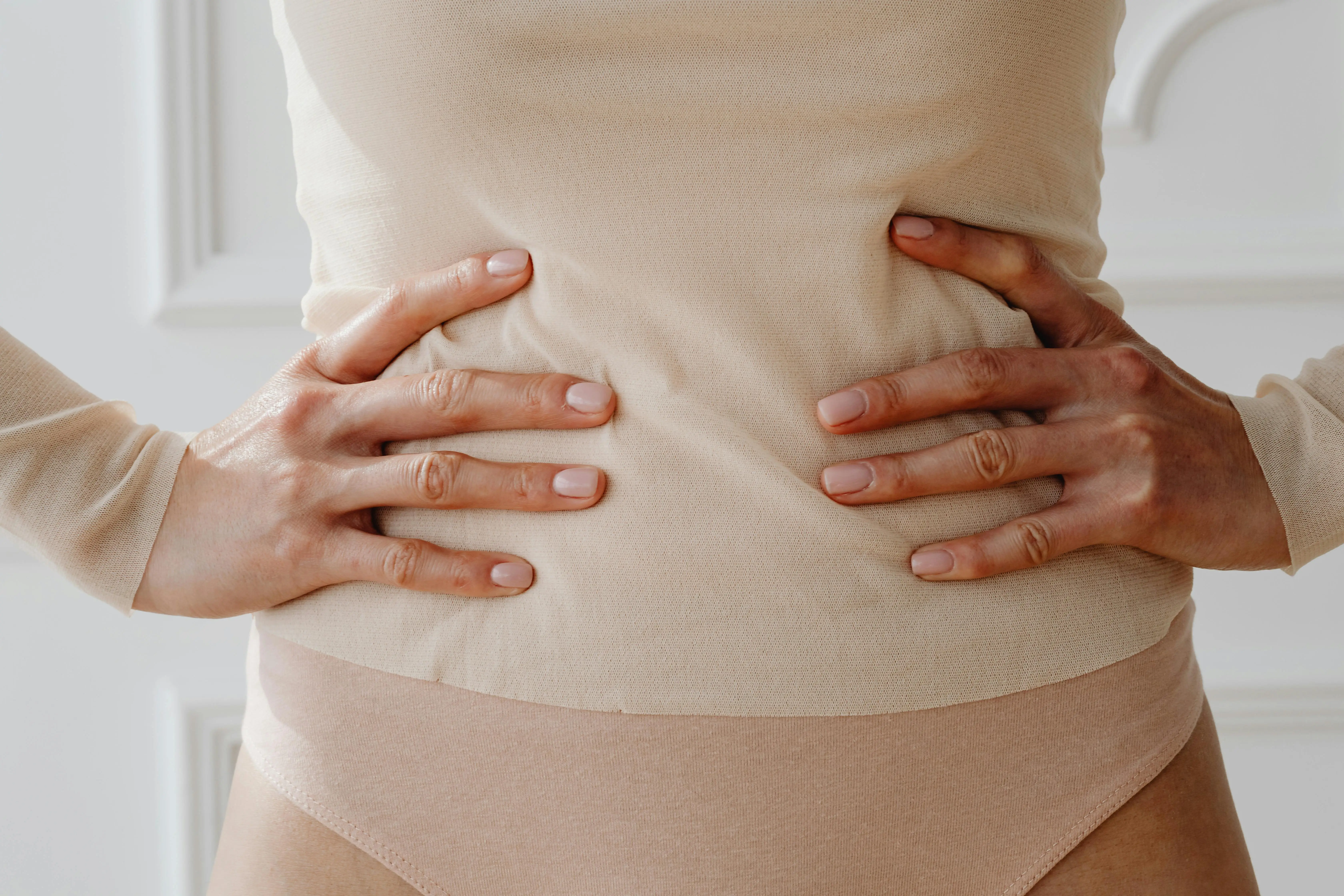 photo of woman holding her abdomen and dealing with stomach cramps